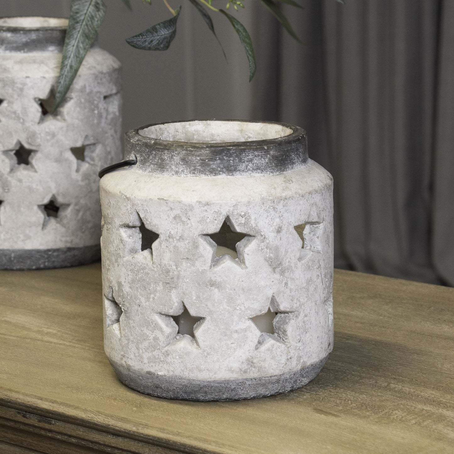 Decorative stone lantern with star cutouts on a wooden surface