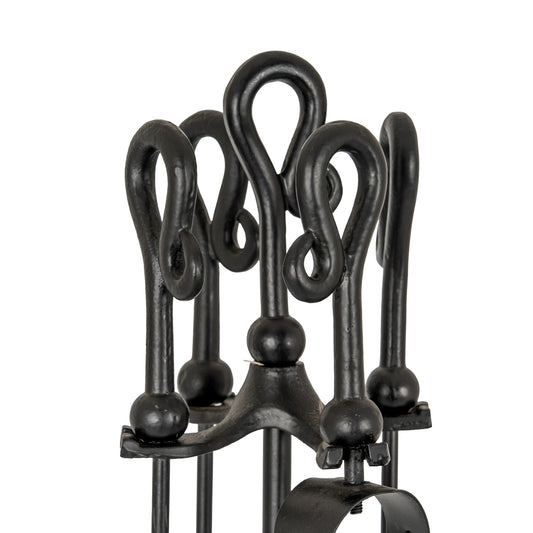Set of black wrought iron fireplace tools on a white background