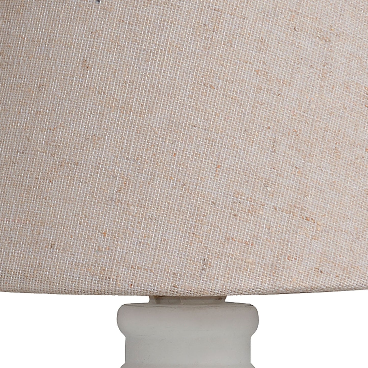 Close-up of a beige textured lampshade with a white base.