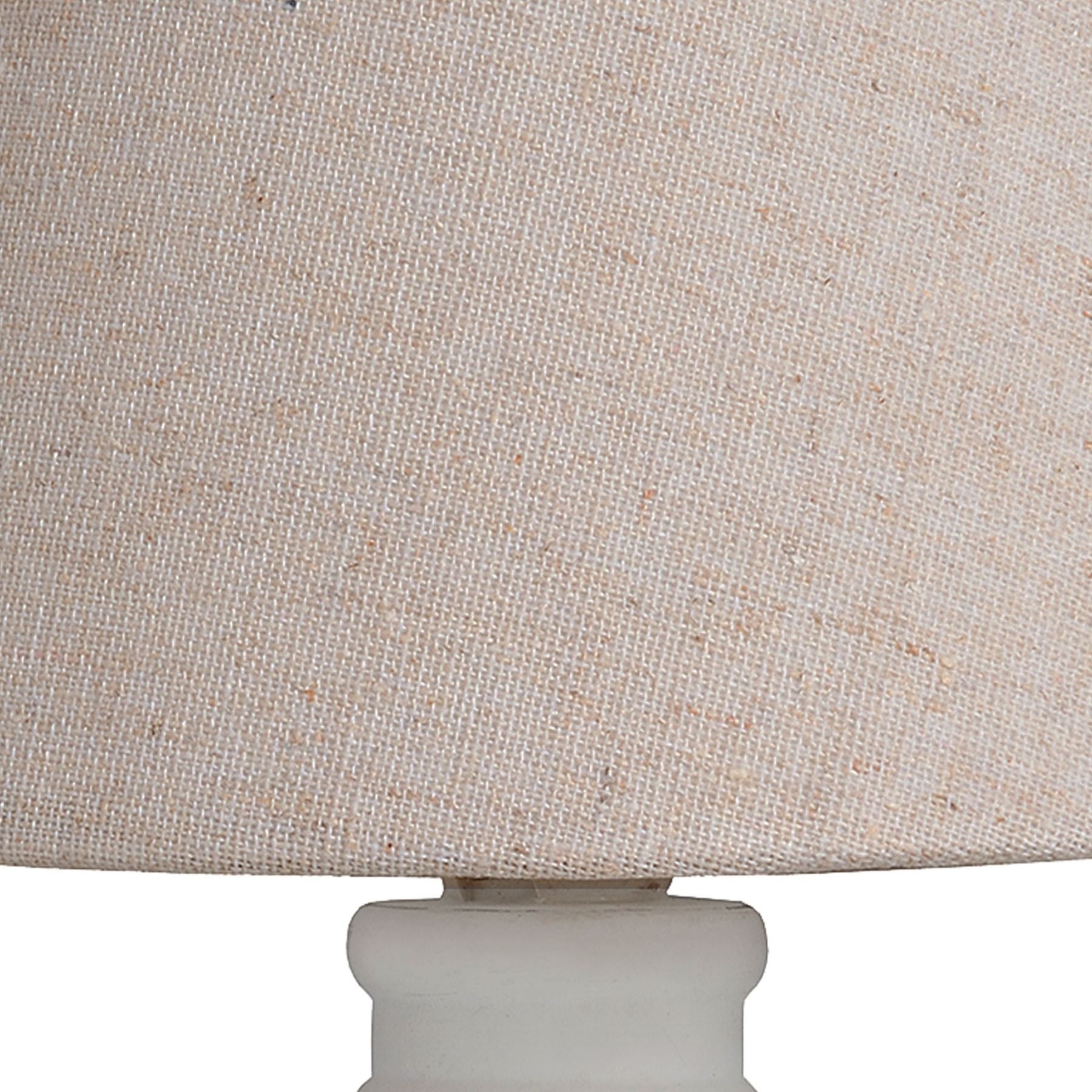 Close-up of a beige textured lampshade with a white base.