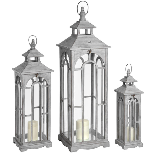 Set of three gray lanterns with candles inside on a white background