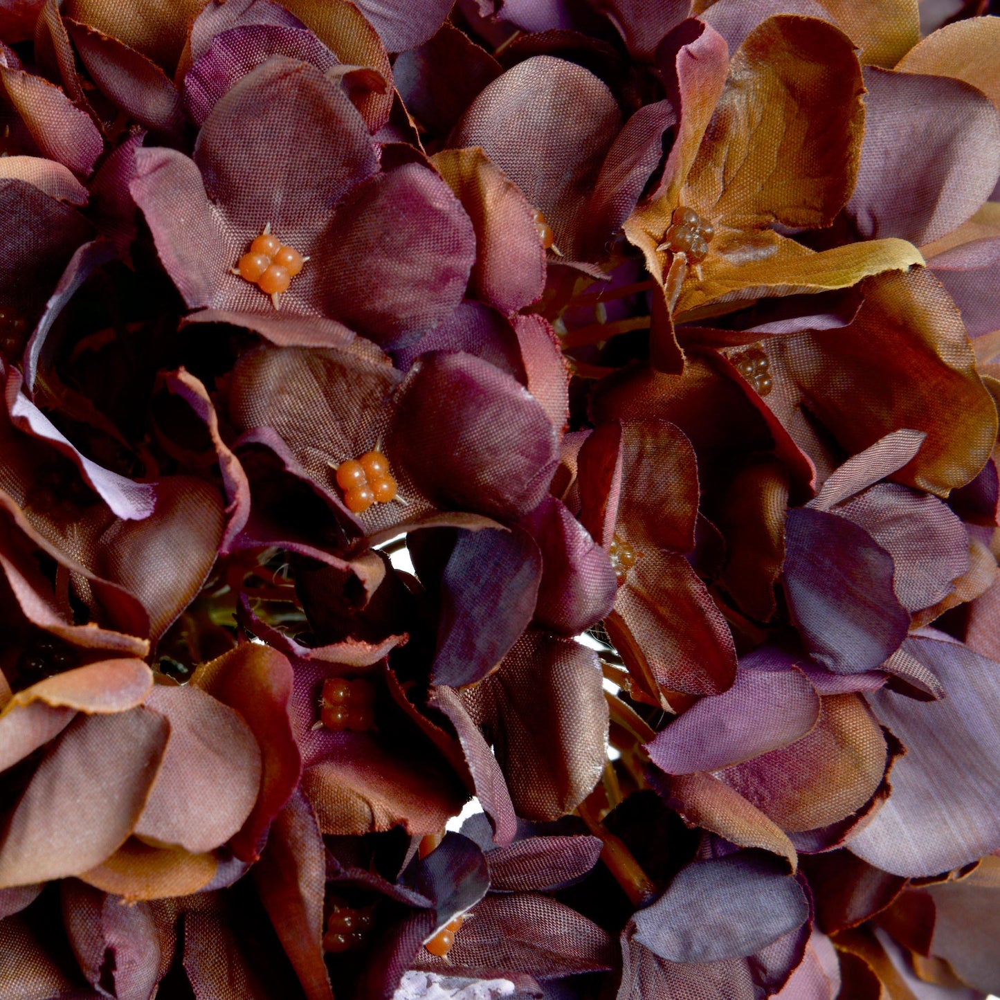 Close-up of a decorative wreath with purple and orange flowers.