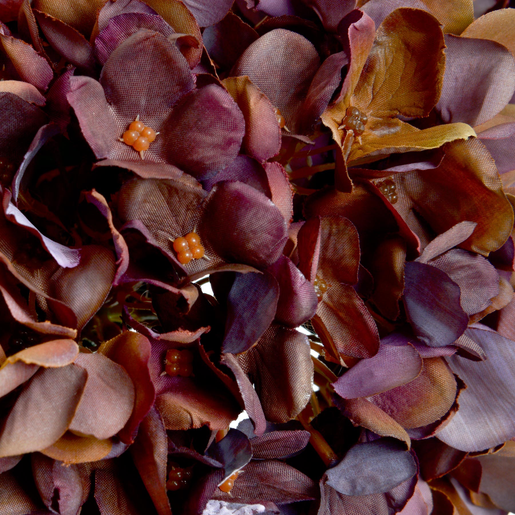 Close-up of a decorative wreath with purple and orange flowers.