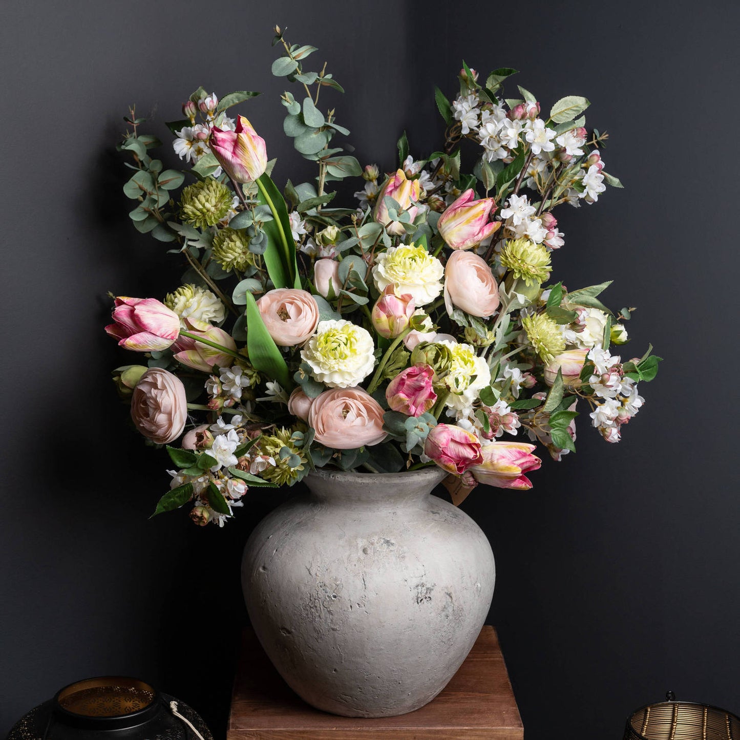 Bouquet of flowers in a gray vase against a dark background