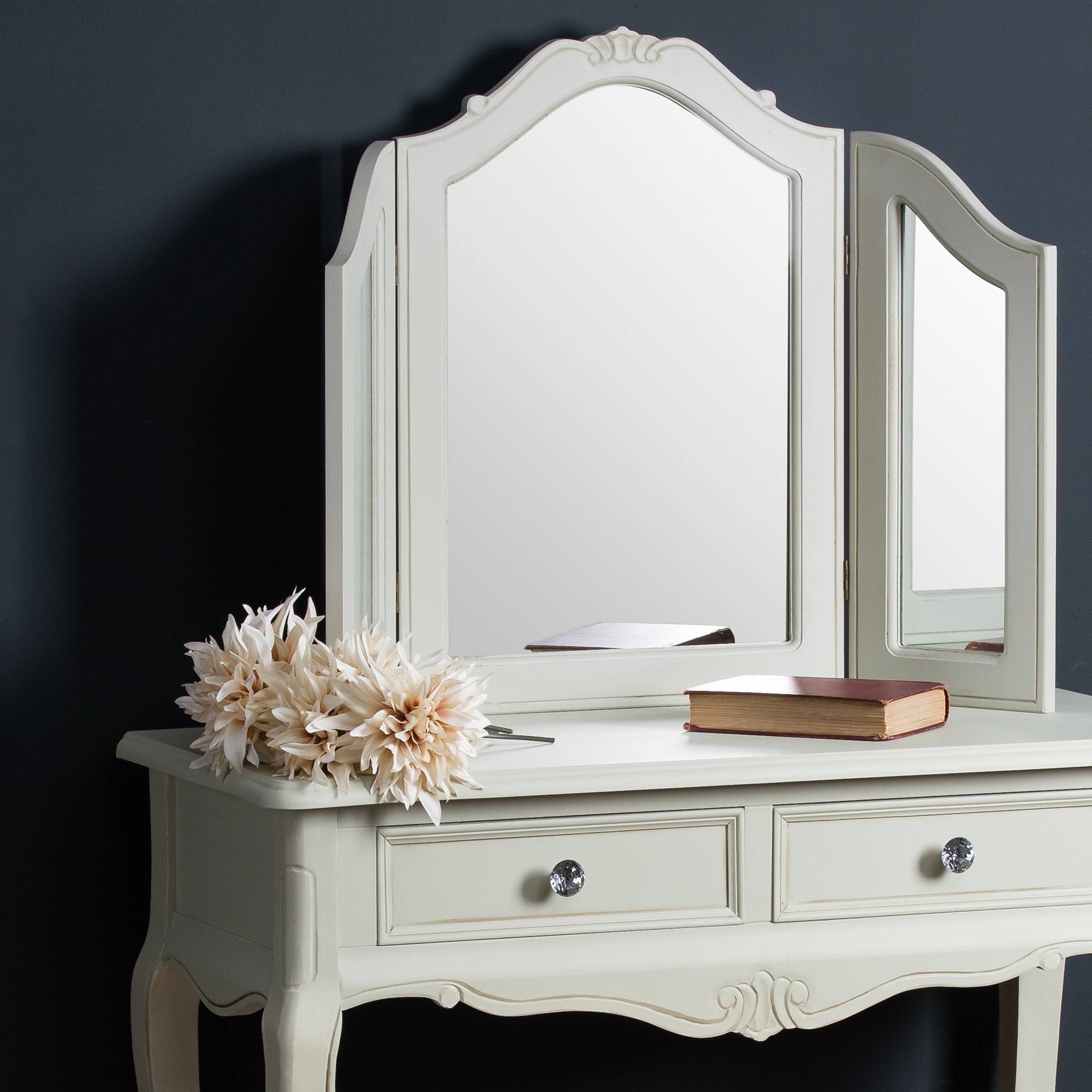 White vanity with a mirror and decorative items on a dark background