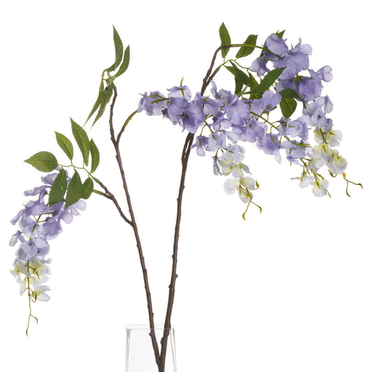 Artificial wisteria branches with purple and white flowers in a clear vase on a white background