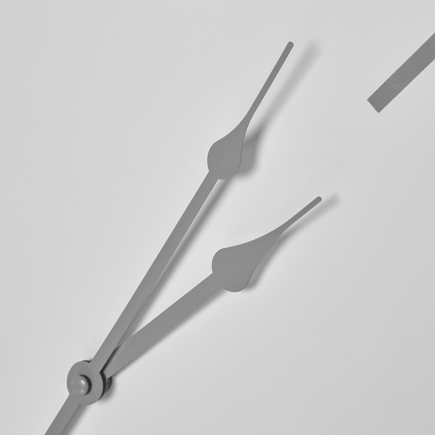 Gray clock hands on a light gray background
