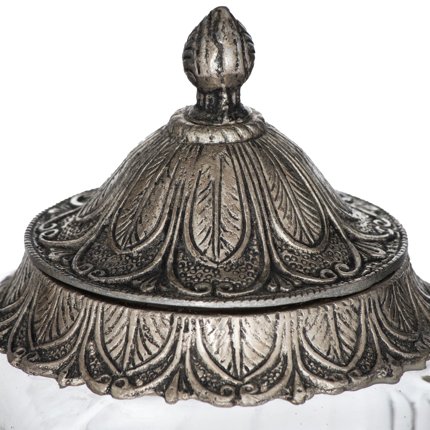 Decorative silver lid with intricate patterns on a white background