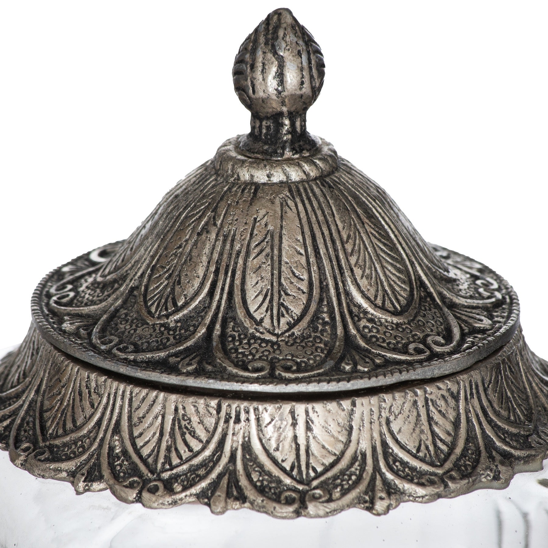 Decorative silver lid with intricate patterns on a white background