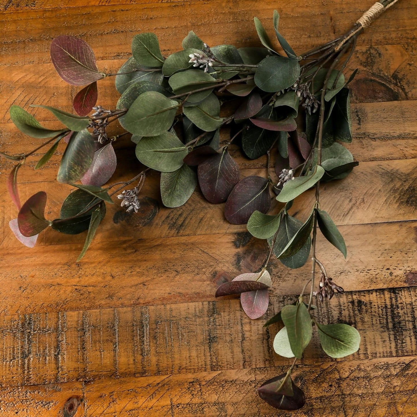 Bouquet of green and purple leaves on a wooden surface