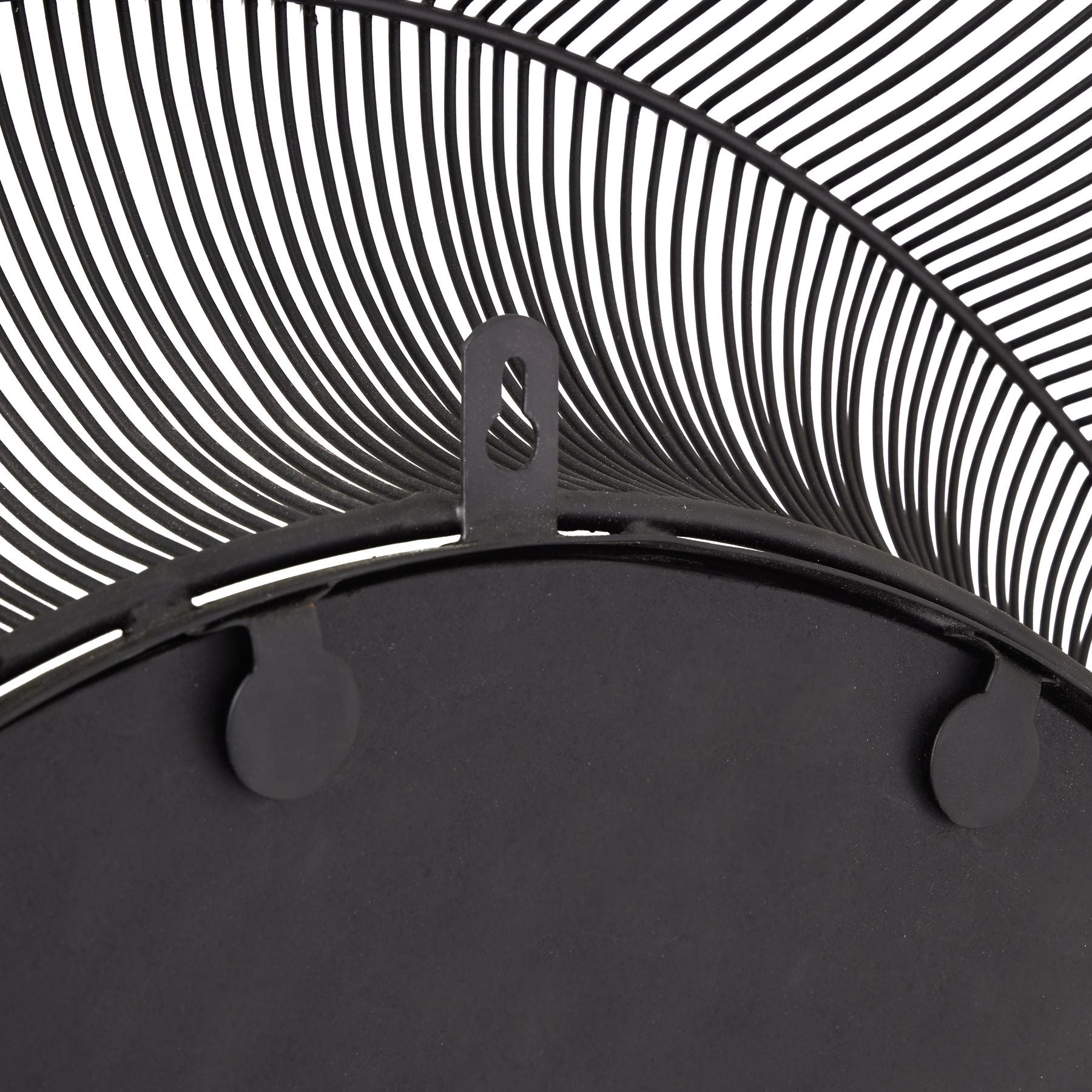 Close-up of a black metal mirror with concentric circular design.