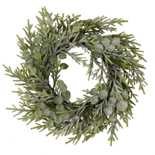 Green artificial wreath with pine needles and berries on a white background