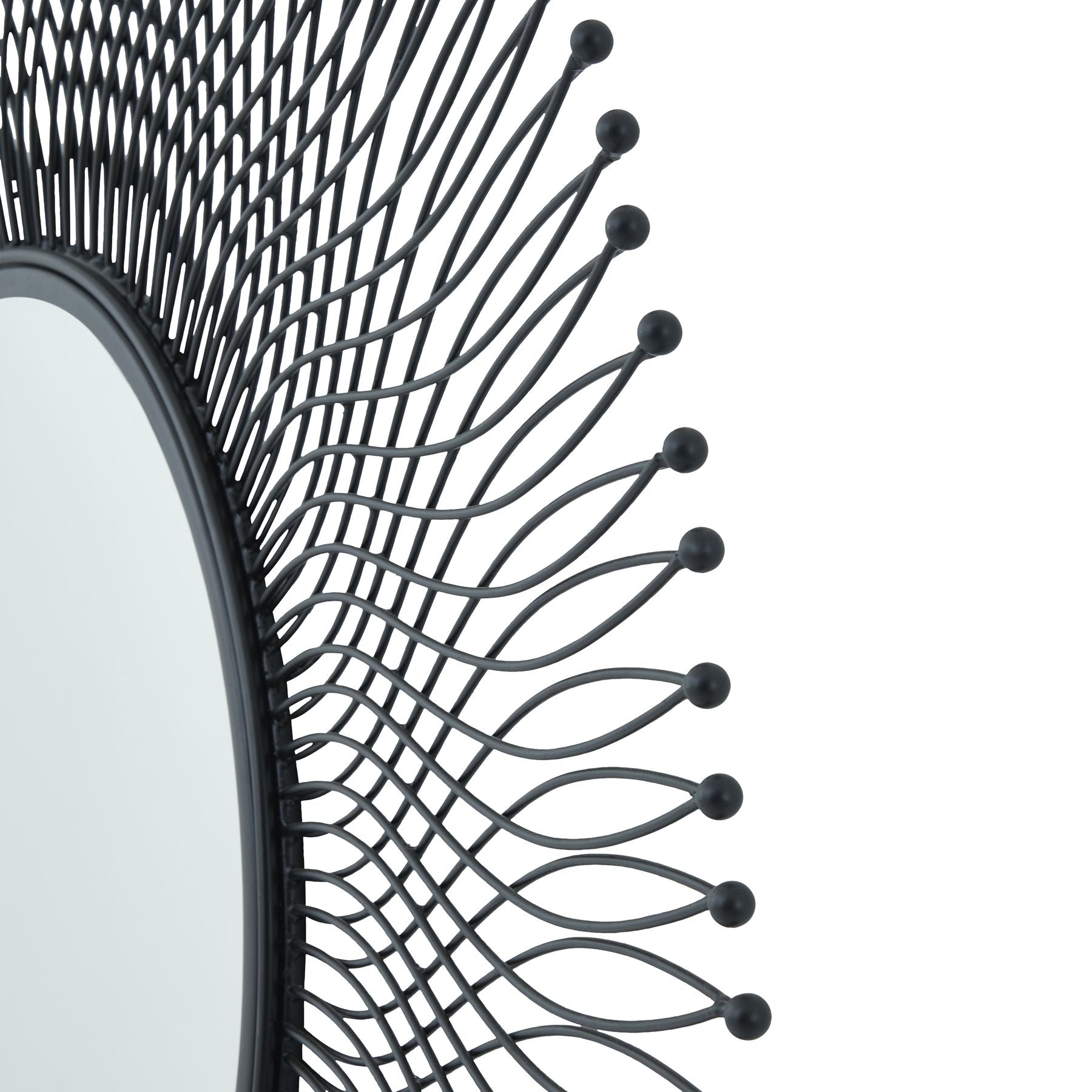Close-up of a black decorative mirror with intricate design on a white background