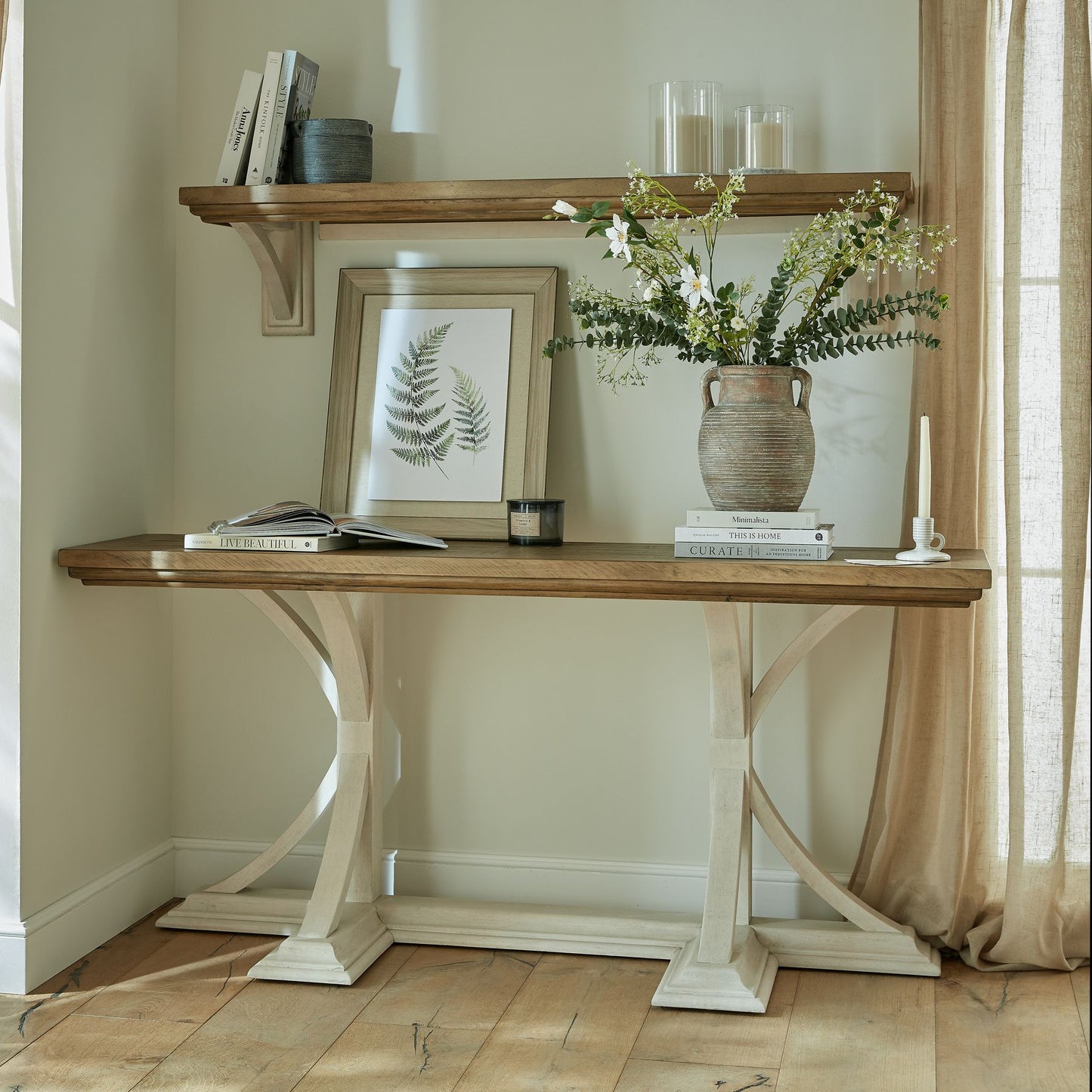Wooden console table with decorative items against a neutral wall.