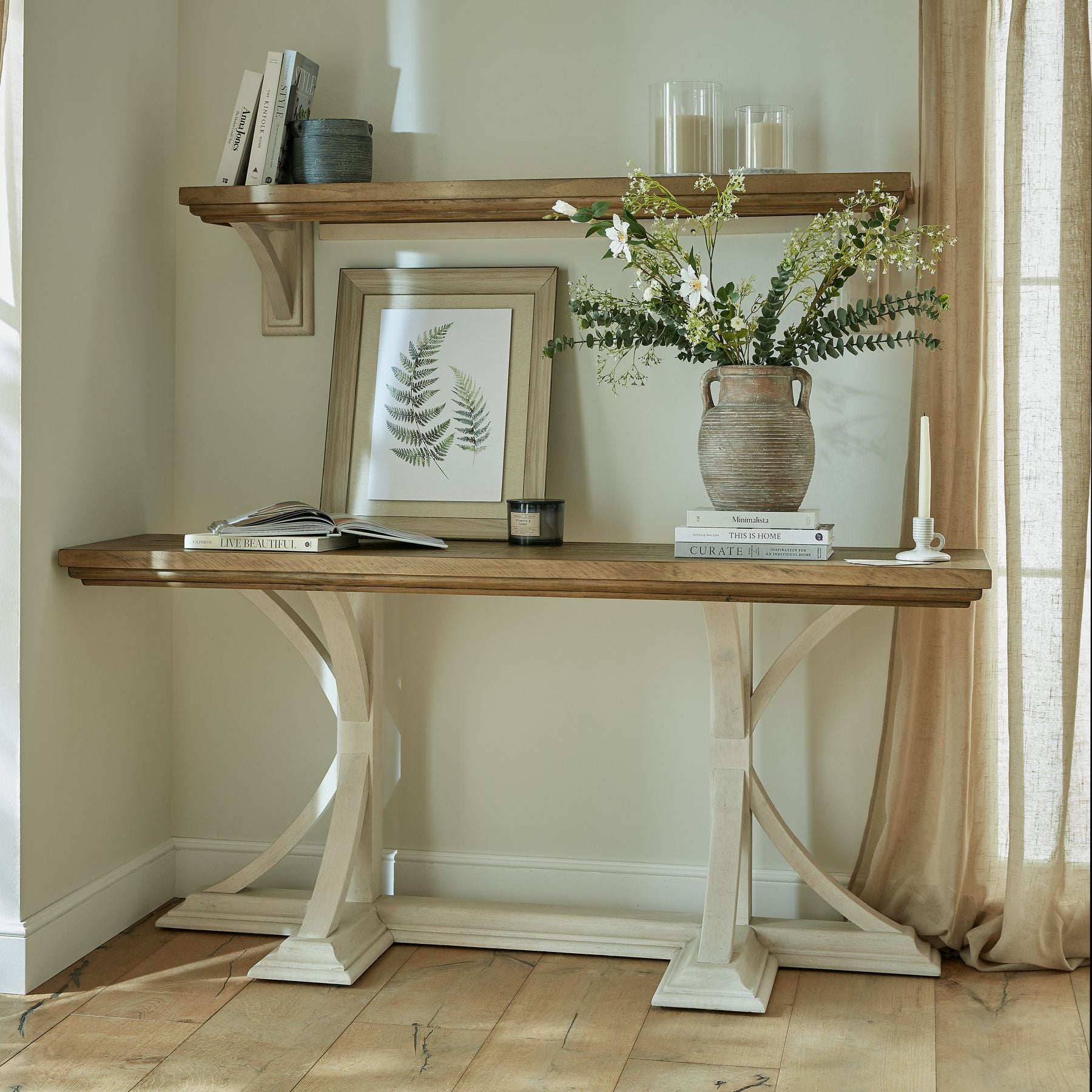 Wooden console table with decorative items against a neutral wall.
