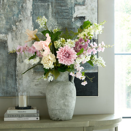 Vase with pink and white flowers on a table in a room setting