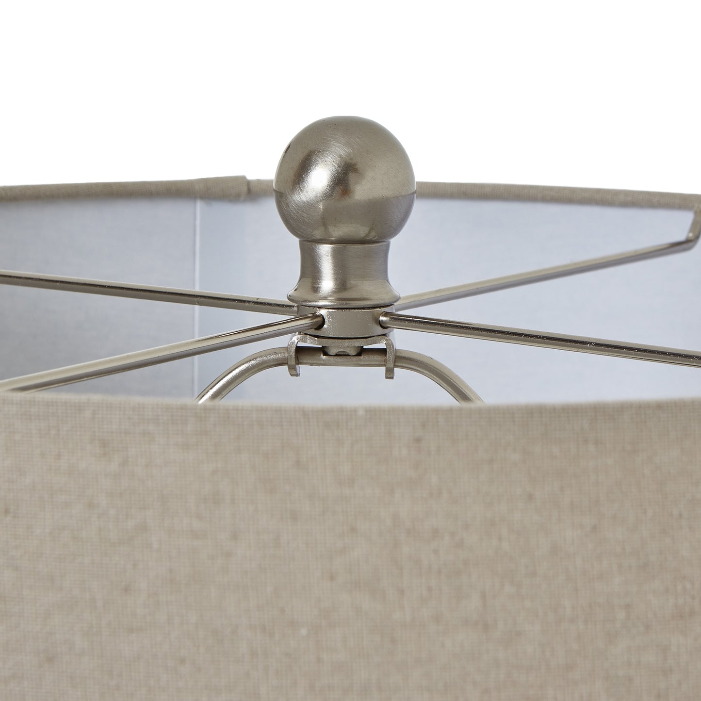Close-up of a lamp with a metallic fixture and beige fabric shade.