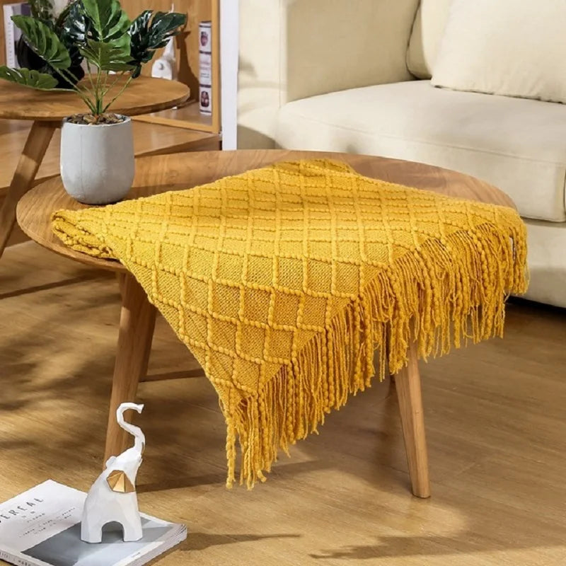 Yellow throw blanket on a wooden coffee table in a living room setting.