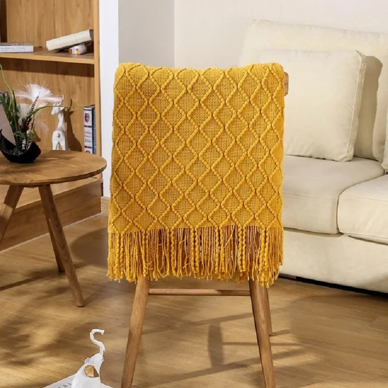 Yellow textured throw blanket on a wooden chair in a living room setting.