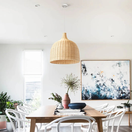 Modern dining room with wooden table, white chairs, and abstract artwork on the wall.