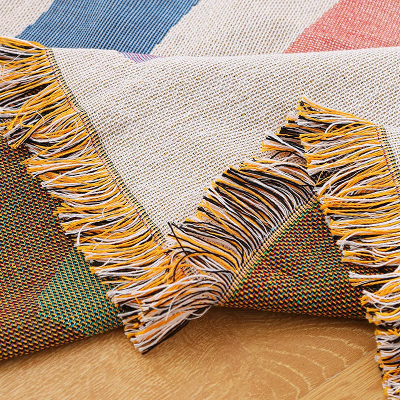 Multicolored woven blanket with fringes on a wooden surface