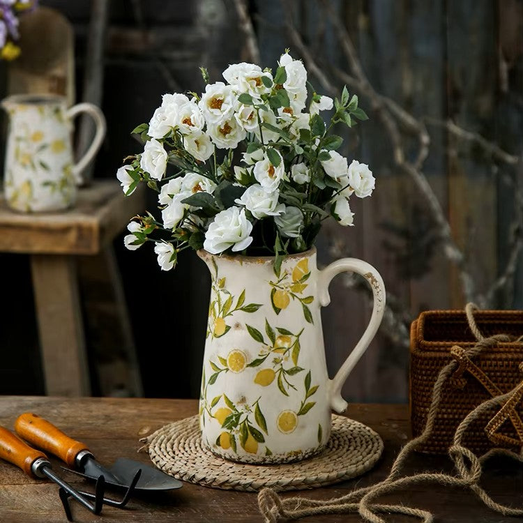 Decorative pitcher with floral arrangement on a wooden table