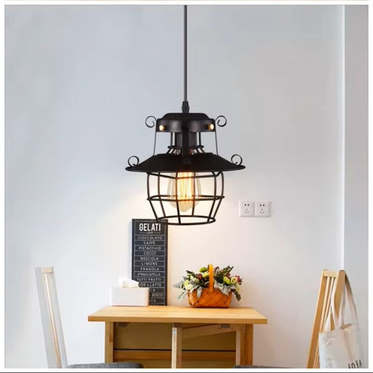 Vintage-style pendant light hanging above a wooden table with decor items.